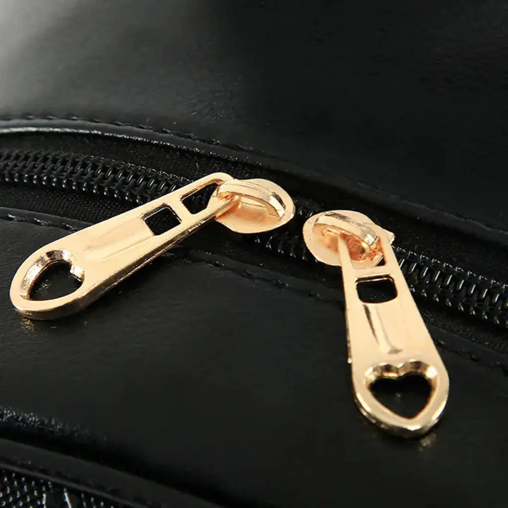 Gros plan sur les tirettes dorées du petit sac à dos cuir élégant Noir